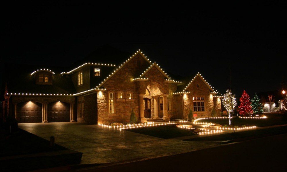 Warm white holiday roofline lighting with landscape bed lighting