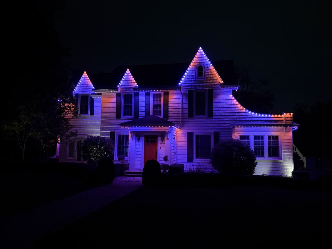 Permanent lighting in multi-color holiday mode on a two-story home